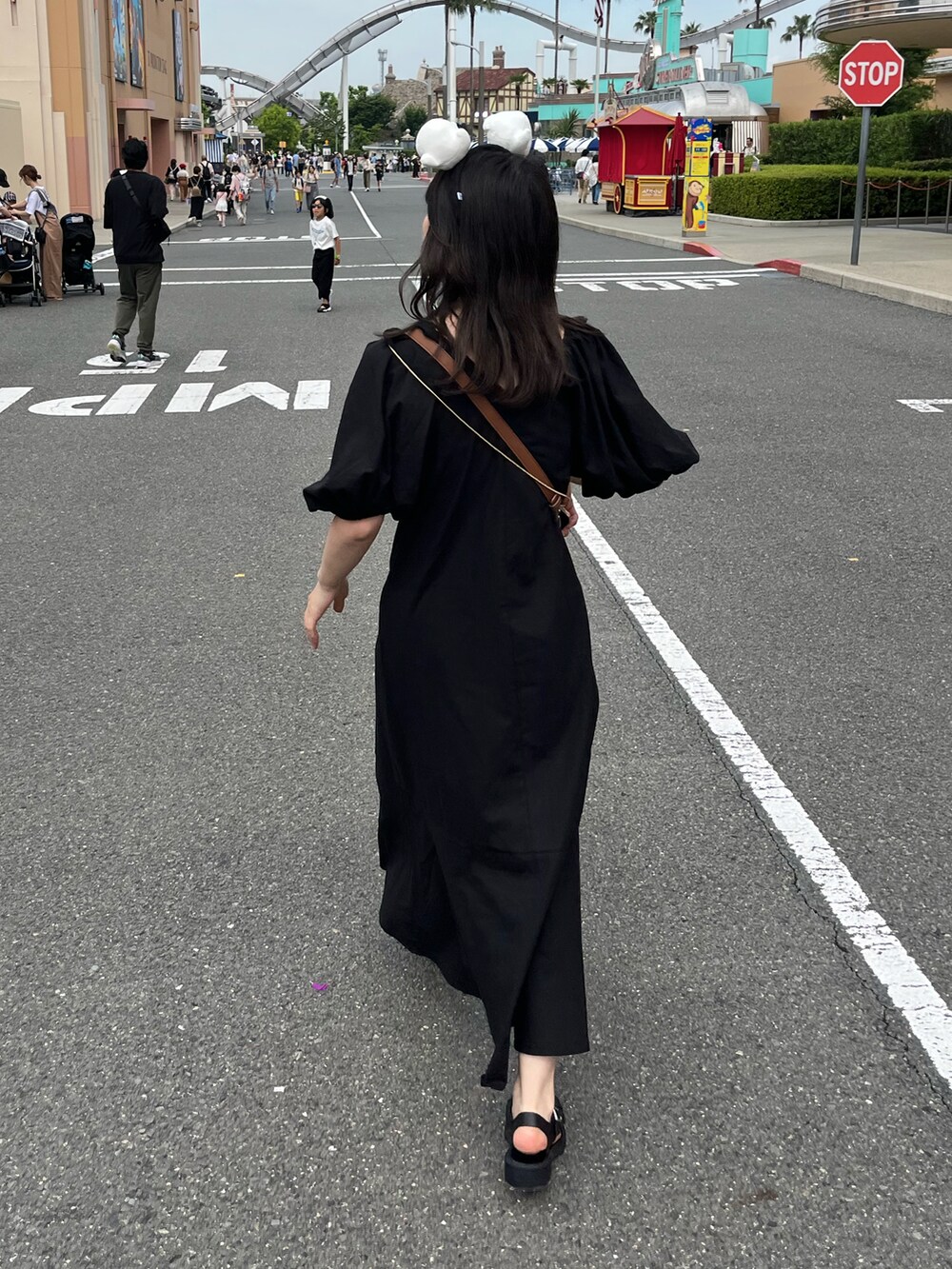 ブラック系のワンピース、ブラック系のサンダル、ブラウン系のショルダーバッグを着用したレディースの夏コーディネートの2枚目の写真