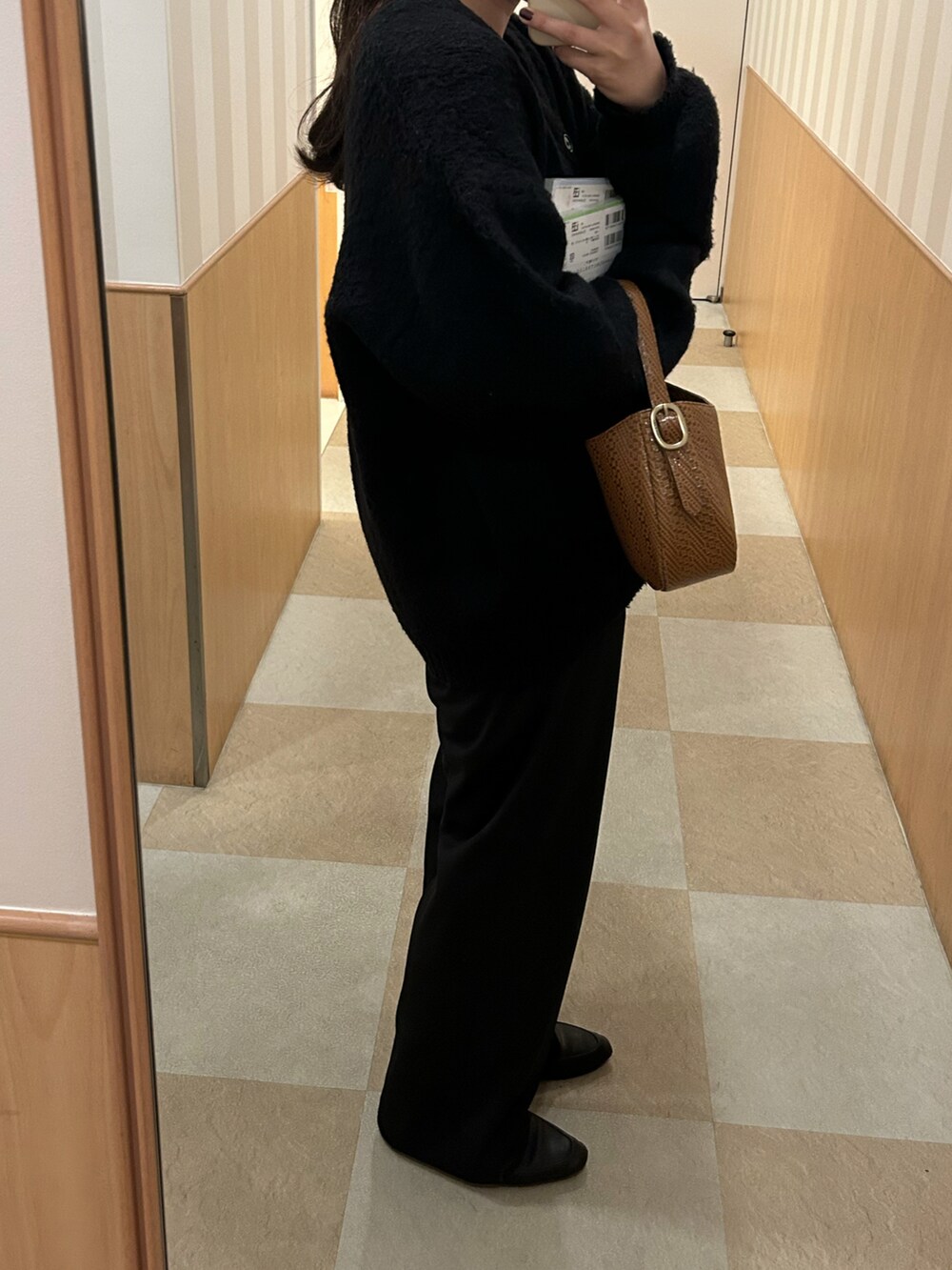 ブラック系のカーディガン/ボレロ、ブラック系のスラックスを着用したレディースの秋コーディネートの2枚目の写真