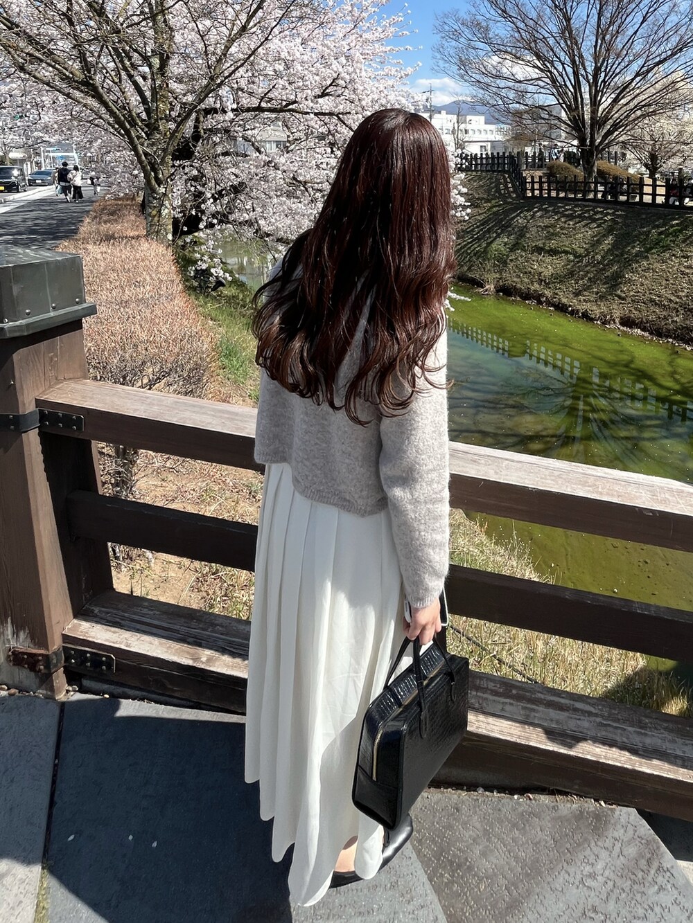 ホワイト系のスカート、ブラック系のバレエシューズを着用したレディースの春コーディネートの2枚目の写真