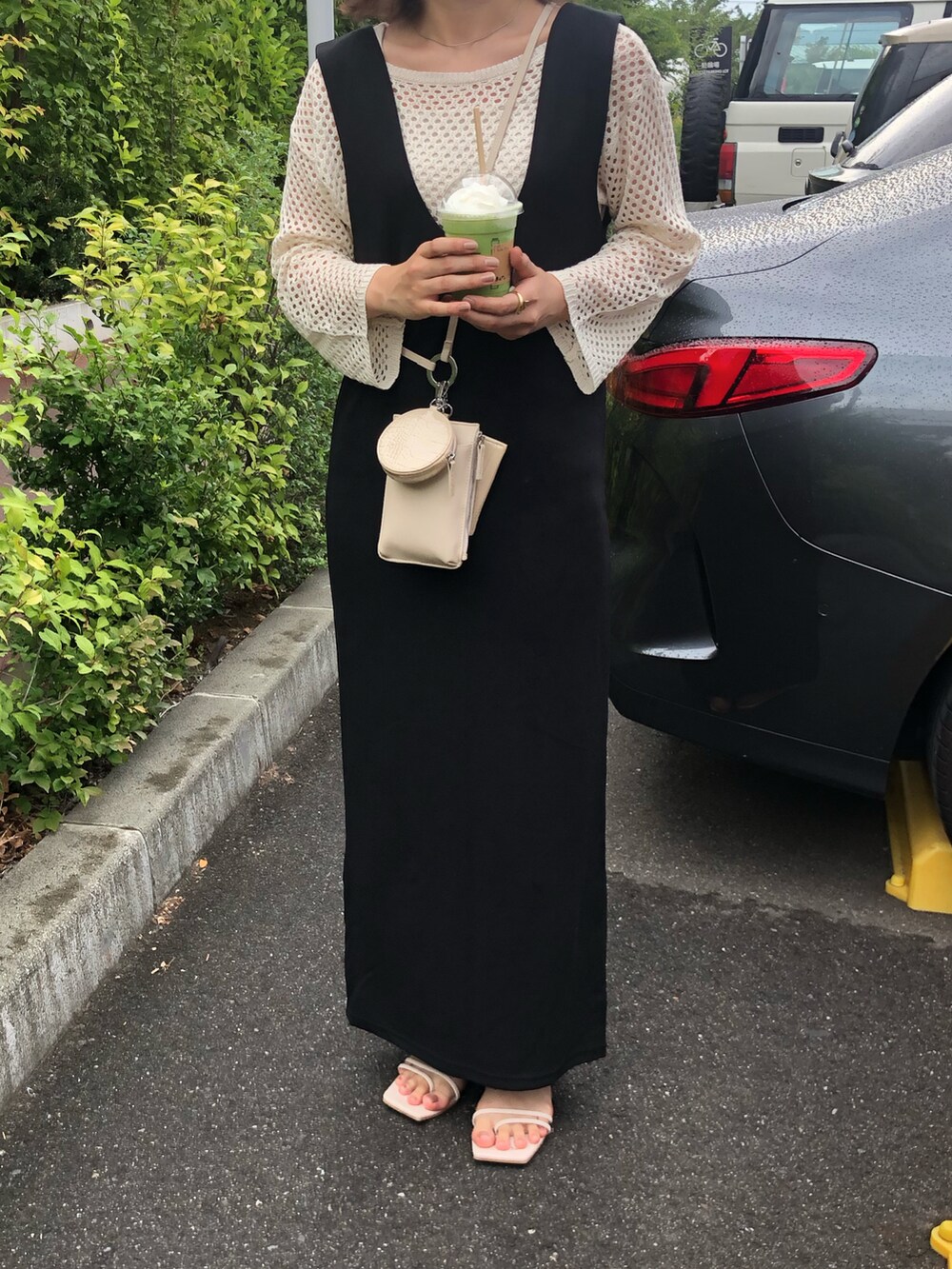 ホワイト系のショルダーバッグ、ホワイト系のニット/セーター、ホワイト系のサンダルを着用したレディースの夏コーディネートの2枚目の写真