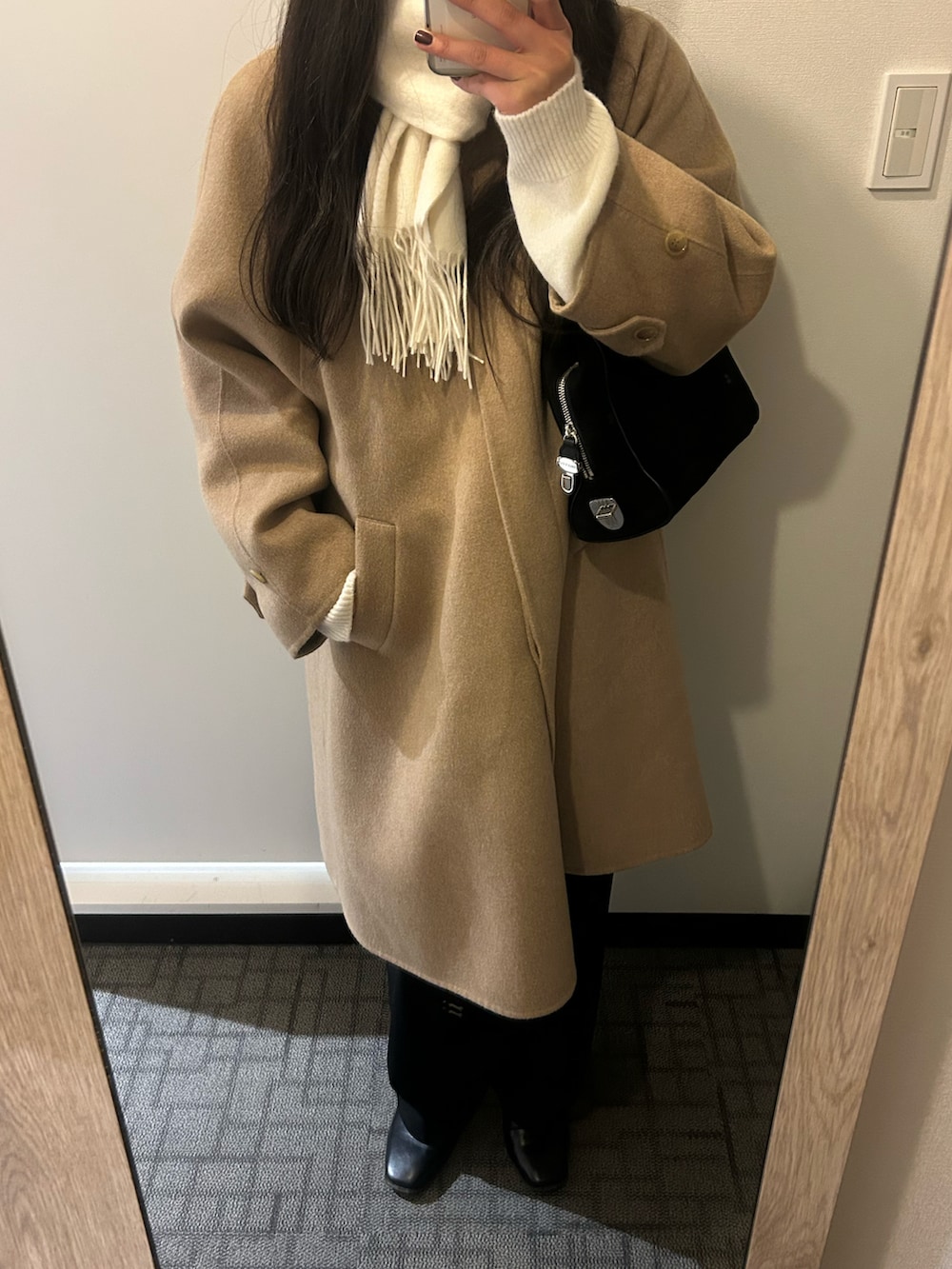 ブラック系のスラックス、ブラック系のブーツ、ベージュ系のジャケット/アウターを着用したレディースの冬コーディネートの2枚目の写真