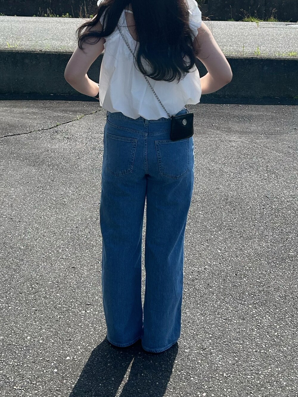 ホワイト系のシャツ/ブラウス、ブルー系のデニムパンツ、ブラック系のショルダーバッグを着用したレディースの夏コーディネートの2枚目の写真