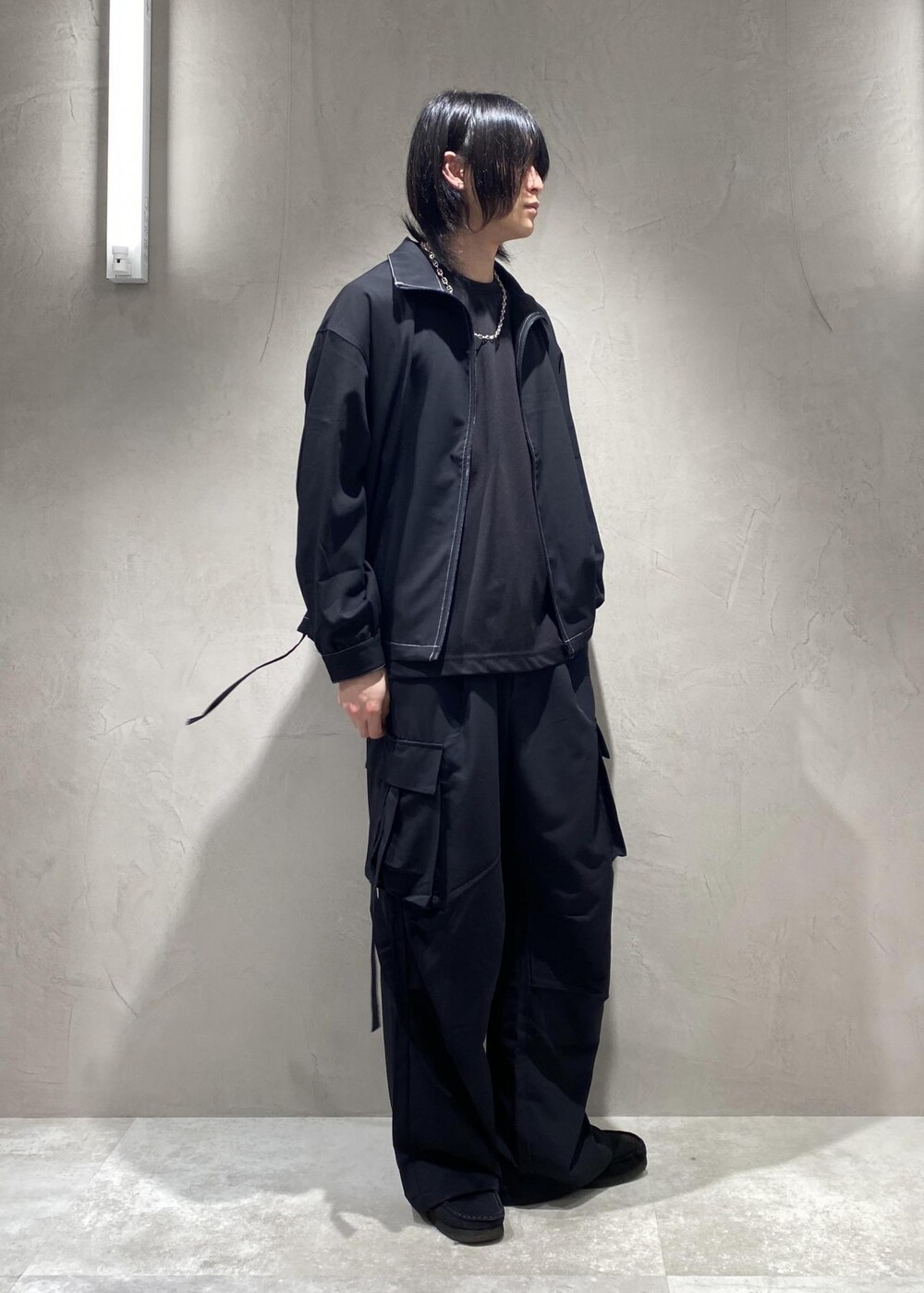 ブラック系のTシャツ/カットソー、ブラック系のモカシン/デッキシューズ、ブラック系のその他パンツを着用したメンズの春コーディネートの4枚目の写真