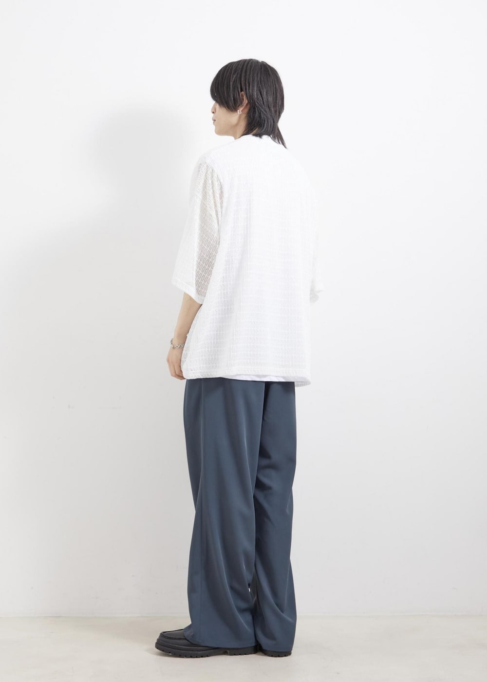 ブラック系のローファー、グリーン系のスラックス、ホワイト系のアンサンブルを着用したメンズの夏コーディネートの2枚目の写真