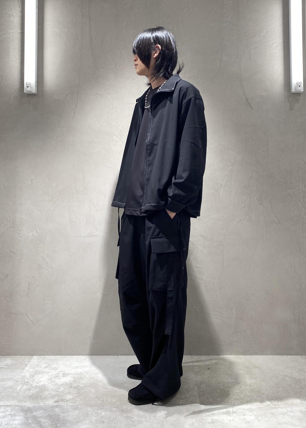 ブラック系のTシャツ/カットソー、ブラック系のモカシン/デッキシューズ、ブラック系のその他パンツを着用したメンズの春コーディネートの2枚目の写真