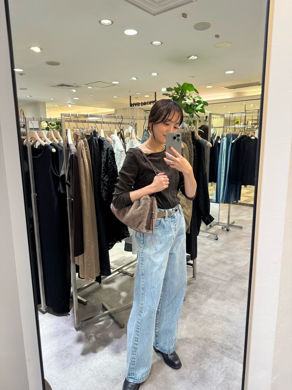 ブラウン系のTシャツ/カットソー、ブルー系のデニムパンツ、ブラウン系のショルダーバッグを着用したレディースの夏コーディネートの2枚目の写真