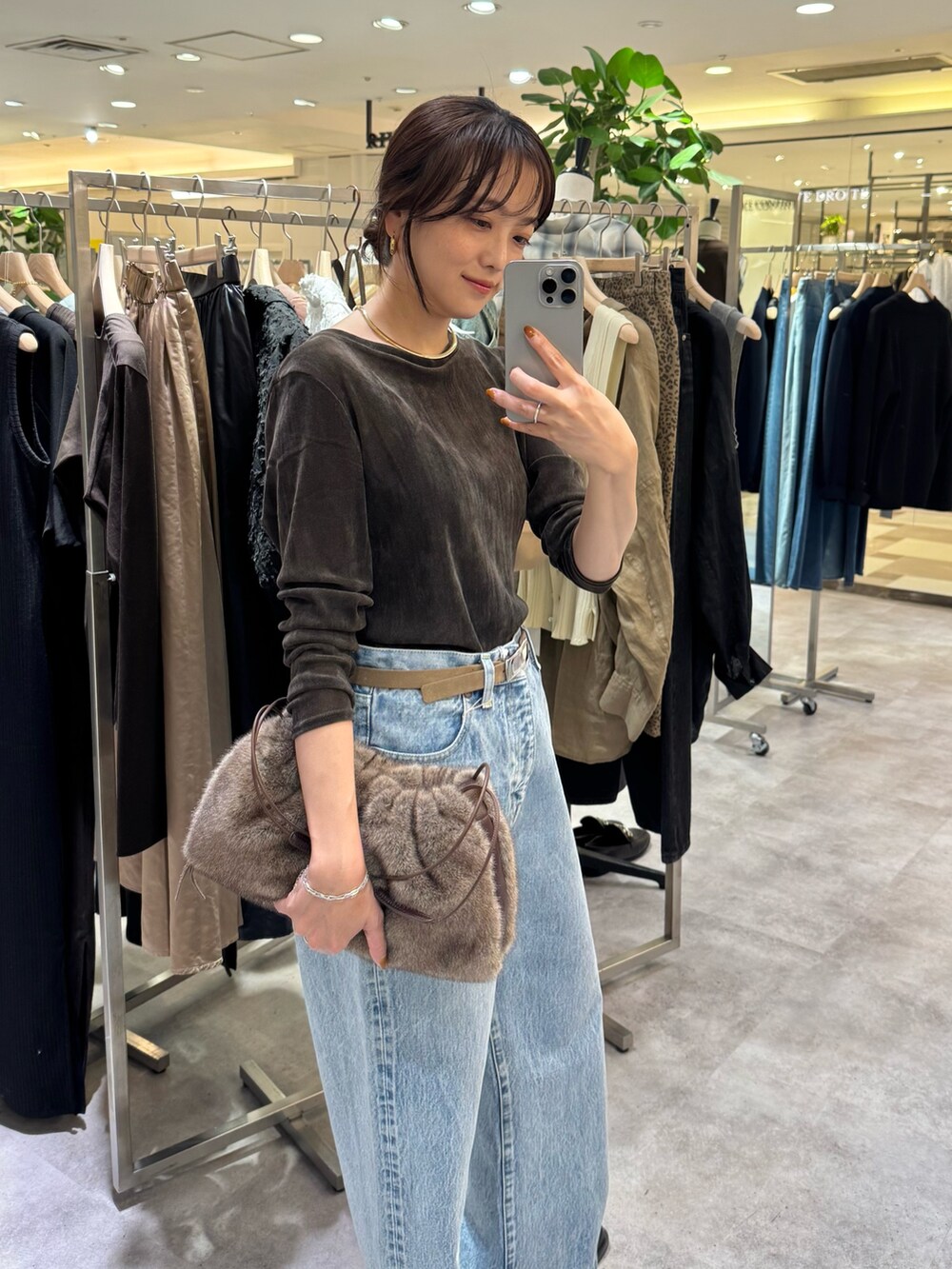 ブラウン系のTシャツ/カットソー、ブルー系のデニムパンツ、ブラウン系のショルダーバッグを着用したレディースの夏コーディネートの3枚目の写真