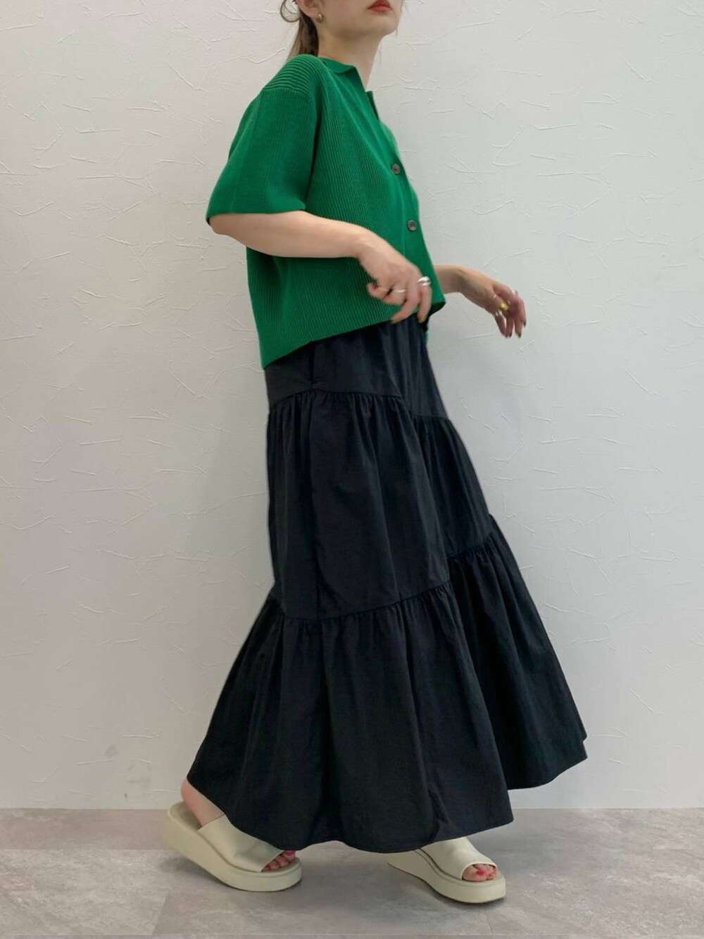 ブラック系のスカート、ホワイト系のサンダル、ブラック系のキャミソールを着用したレディースの夏コーディネートの2枚目の写真