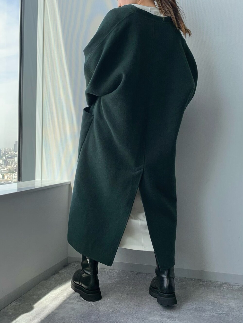 ホワイト系のショルダーバッグ、ブラック系のブーツ、グリーン系のノーカラーコートを着用したレディースの夏コーディネートの3枚目の写真