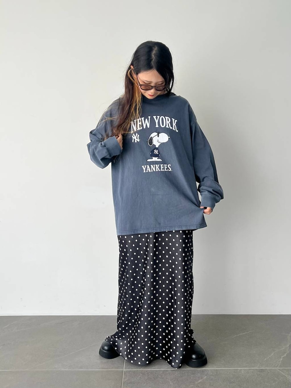 ブラック系のスカート、ブラック系のサンダル、ブルー系のTシャツ/カットソーを着用したレディースの秋コーディネートの2枚目の写真