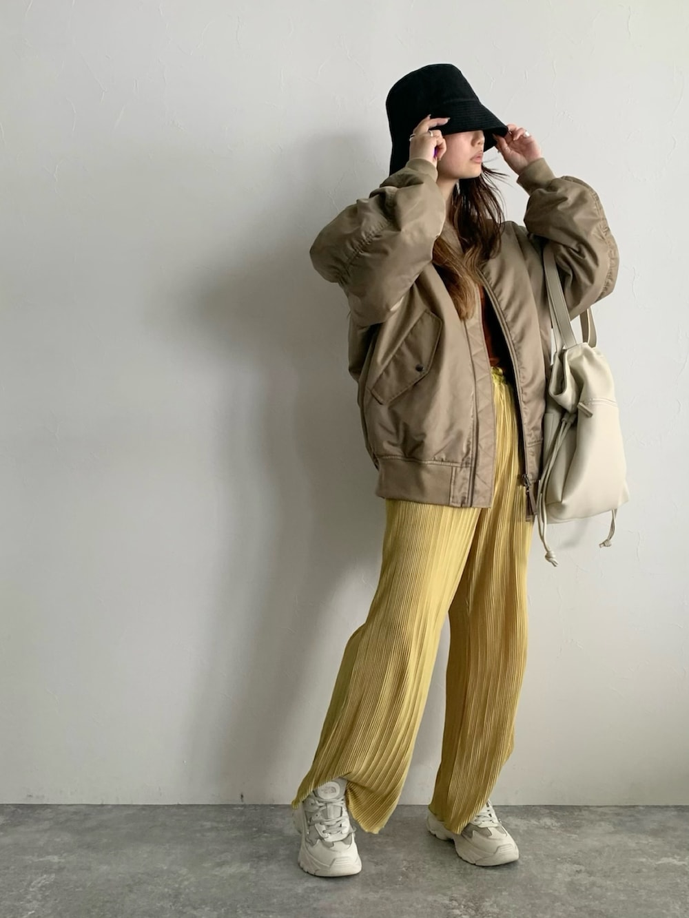 ベージュ系のMA-1、ホワイト系のトートバッグを着用したレディースの夏コーディネートの3枚目の写真