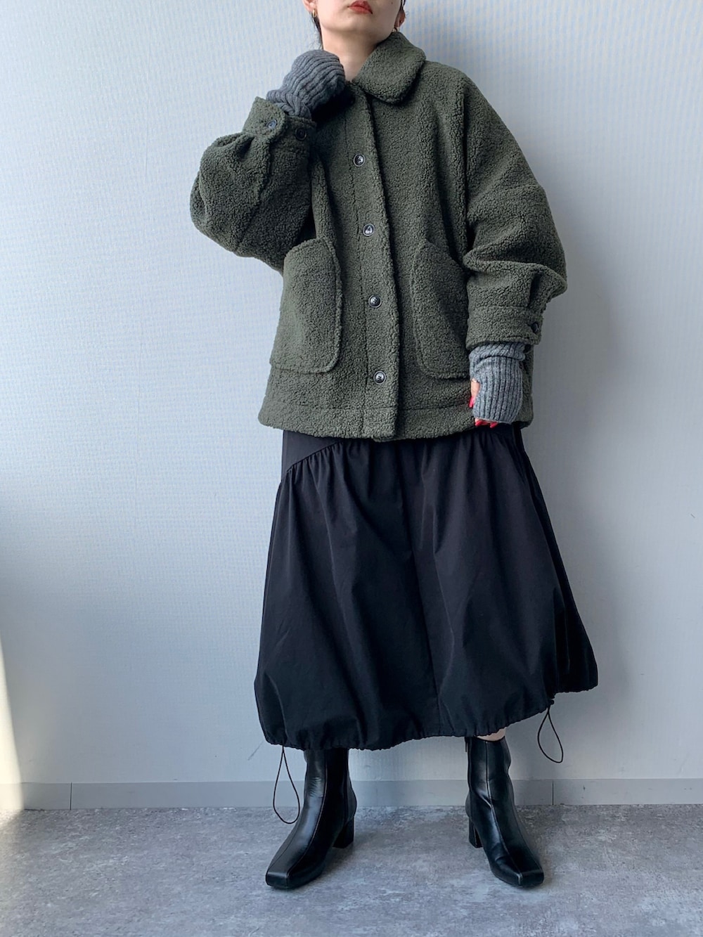 ブラック系のブーツ、グリーン系のブルゾン、ブラック系のワンピースを着用したレディースの夏コーディネートの4枚目の写真