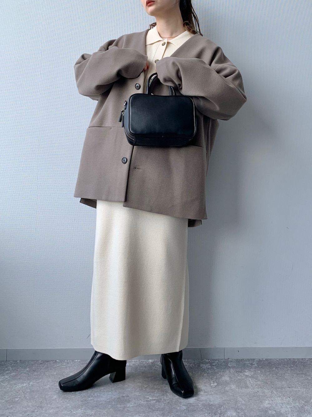 ブラック系のブーツ、ブラック系のショルダーバッグ、ホワイト系のワンピースを着用したレディースの夏コーディネートの3枚目の写真