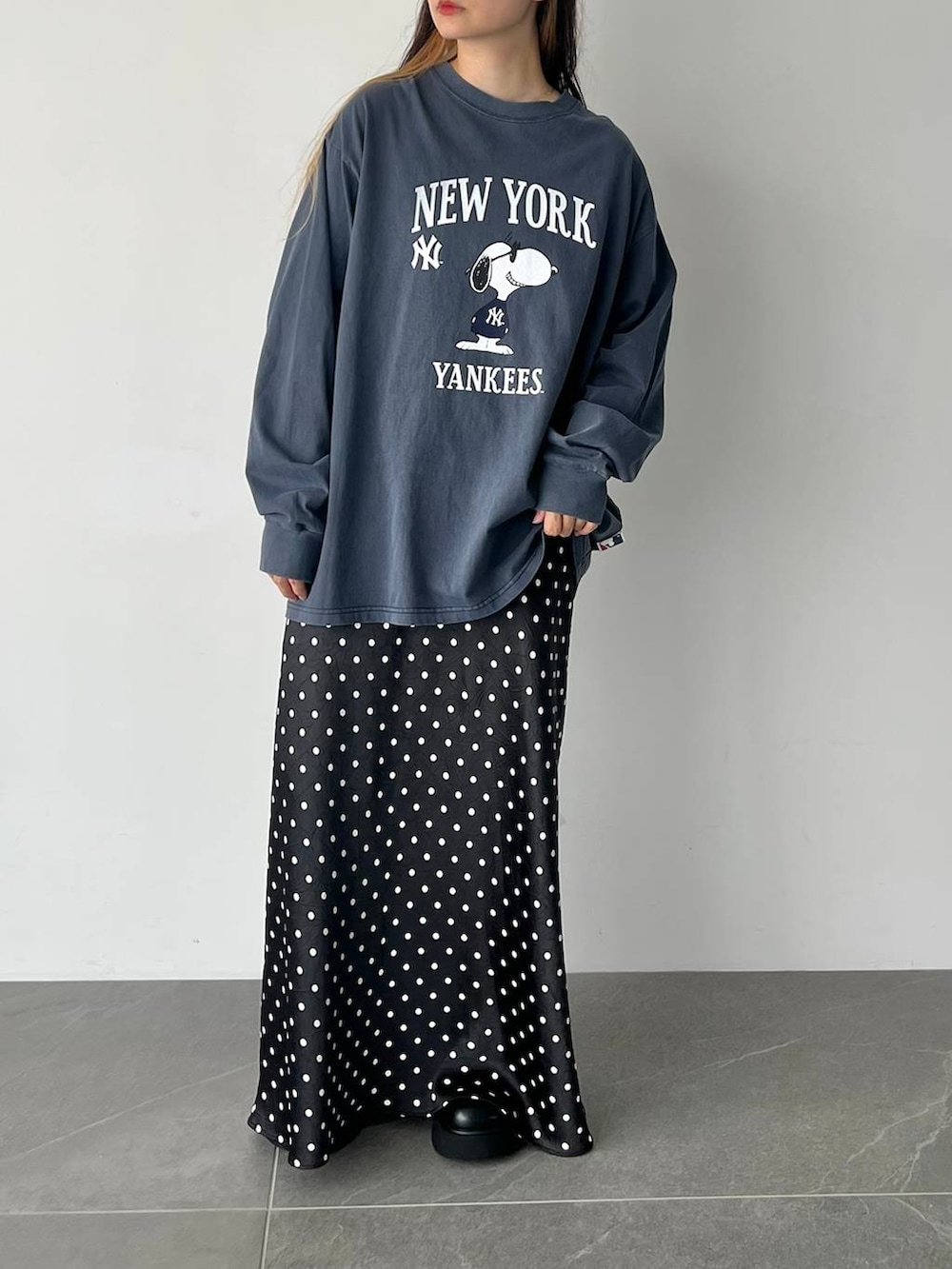 ブラック系のスカート、ブラック系のサンダル、ブルー系のTシャツ/カットソーを着用したレディースの秋コーディネートの4枚目の写真