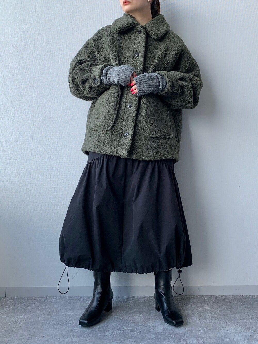 ブラック系のブーツ、グリーン系のブルゾン、ブラック系のワンピースを着用したレディースの夏コーディネートの5枚目の写真