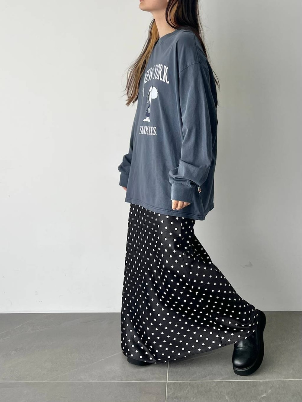 ブラック系のスカート、ブラック系のサンダル、ブルー系のTシャツ/カットソーを着用したレディースの秋コーディネートの3枚目の写真