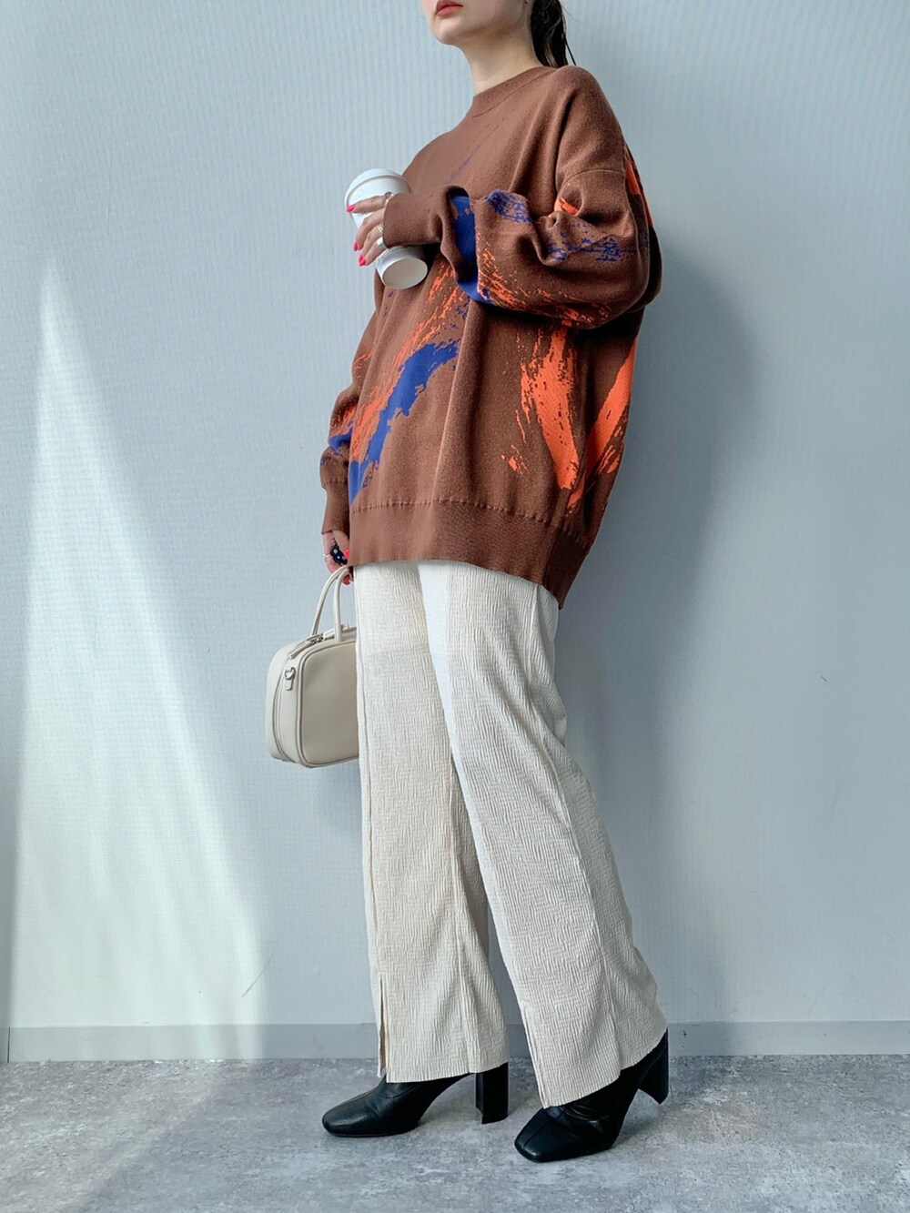 ブラック系のブーツ、ホワイト系のその他パンツ、ブラウン系のニット/セーターを着用したレディースの夏コーディネートの2枚目の写真