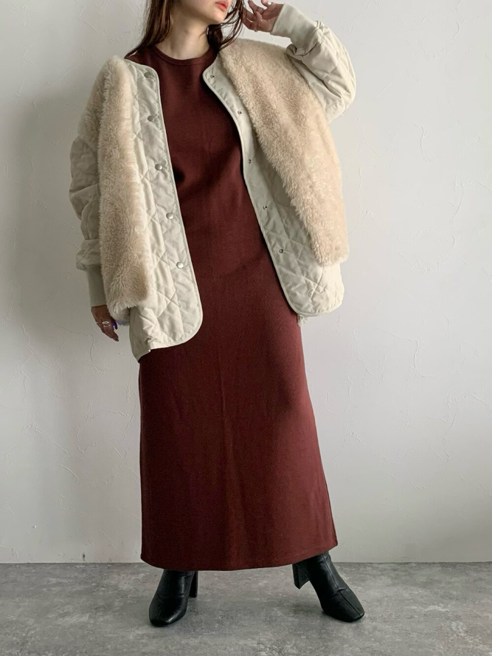 ブラウン系のワンピース、ブラック系のブーツ、ホワイト系のブルゾンを着用したレディースの夏コーディネートの5枚目の写真