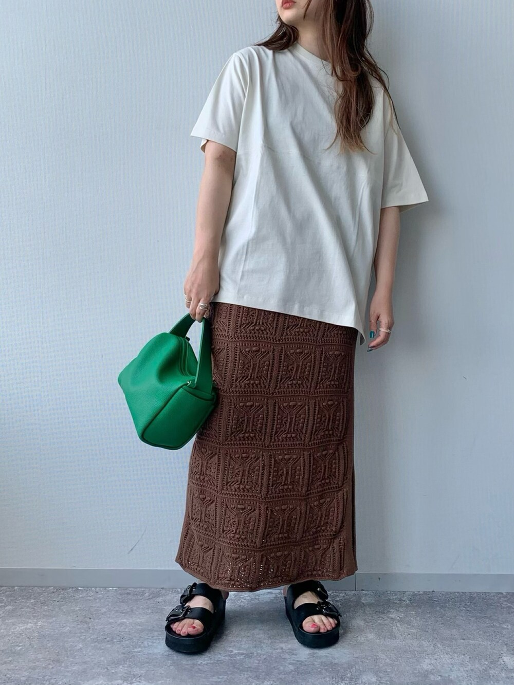 ブラック系のサンダル、ブラウン系のスカート、グリーン系のショルダーバッグを着用したレディースの夏コーディネートの3枚目の写真