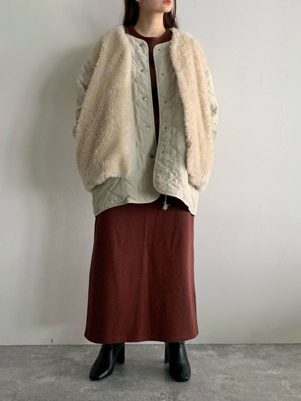 ブラウン系のワンピース、ブラック系のブーツ、ホワイト系のブルゾンを着用したレディースの夏コーディネートの4枚目の写真