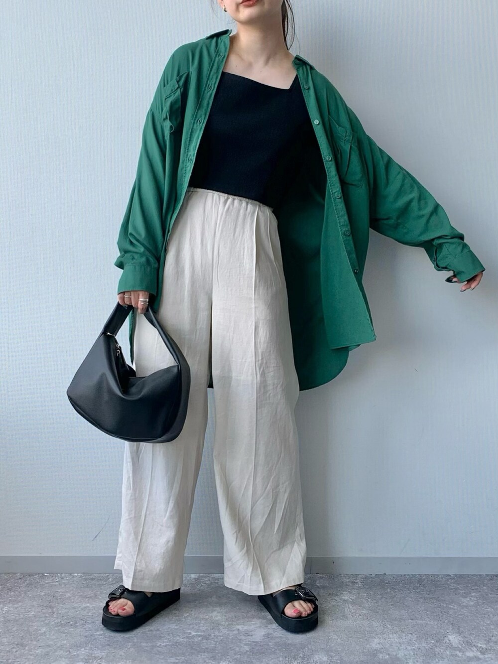 ブラック系のサンダル、ホワイト系のショルダーバッグ、グリーン系のトップスを着用したレディースの夏コーディネートの4枚目の写真