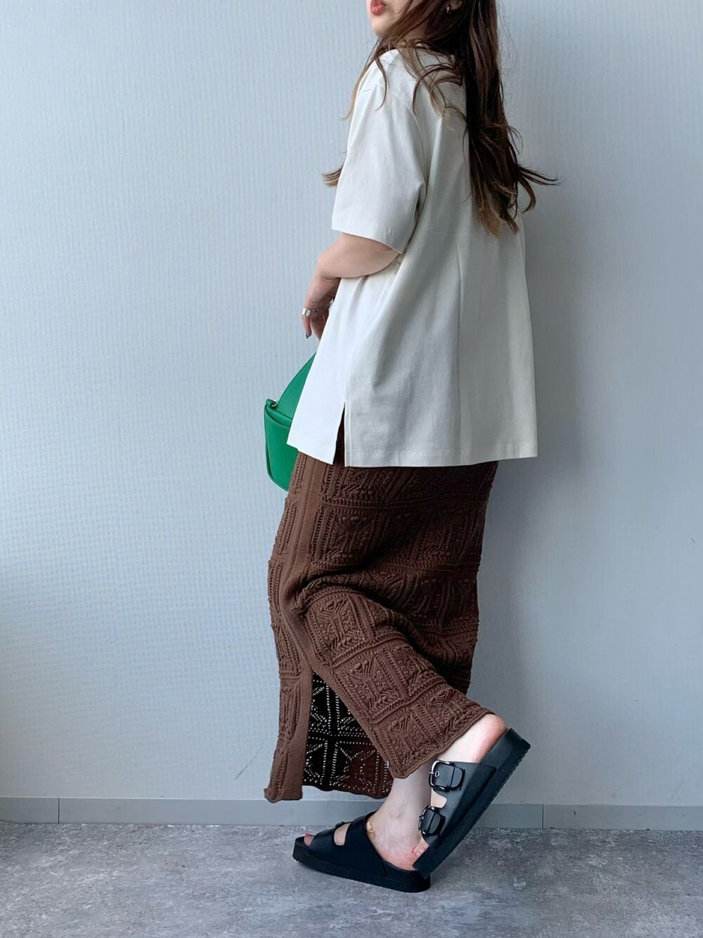 ブラック系のサンダル、ブラウン系のスカート、グリーン系のショルダーバッグを着用したレディースの夏コーディネートの2枚目の写真