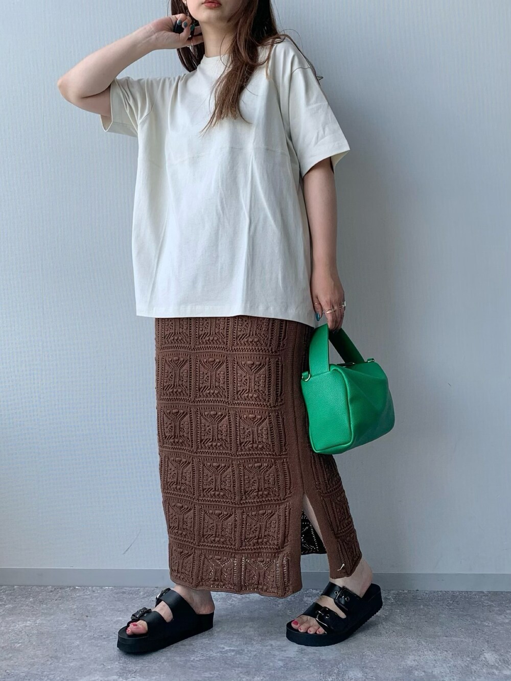 ブラック系のサンダル、ブラウン系のスカート、グリーン系のショルダーバッグを着用したレディースの夏コーディネートの4枚目の写真