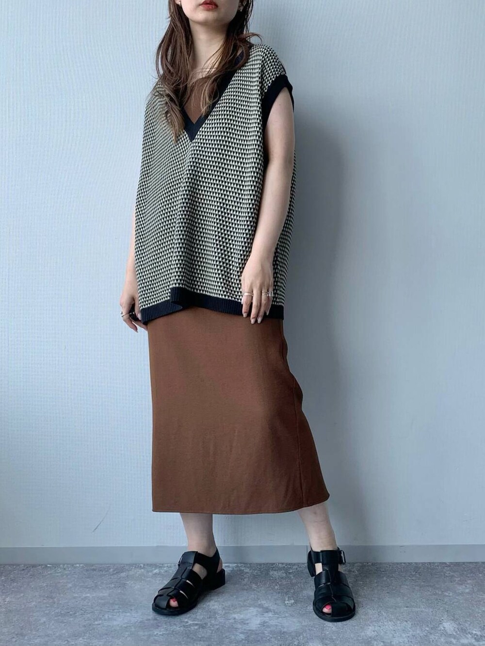 ブラック系のサンダル、ブラウン系のワンピース、ブラック系のベストを着用したレディースの夏コーディネートの2枚目の写真