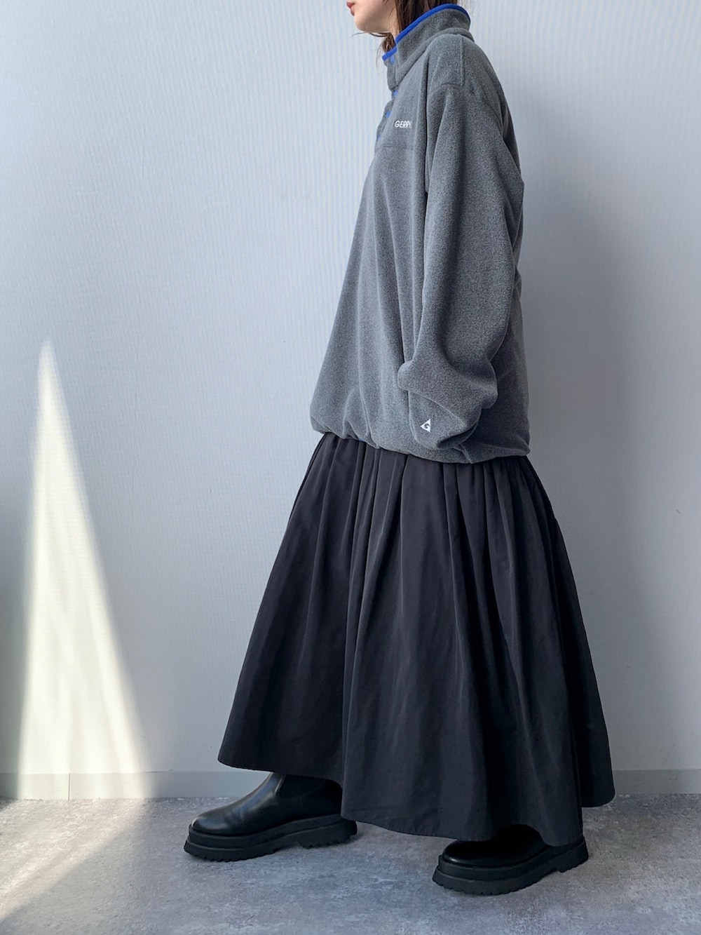 グレー系のTシャツ/カットソー、グリーン系のスカート、ブラック系のブーツを着用したレディースの夏コーディネートの3枚目の写真