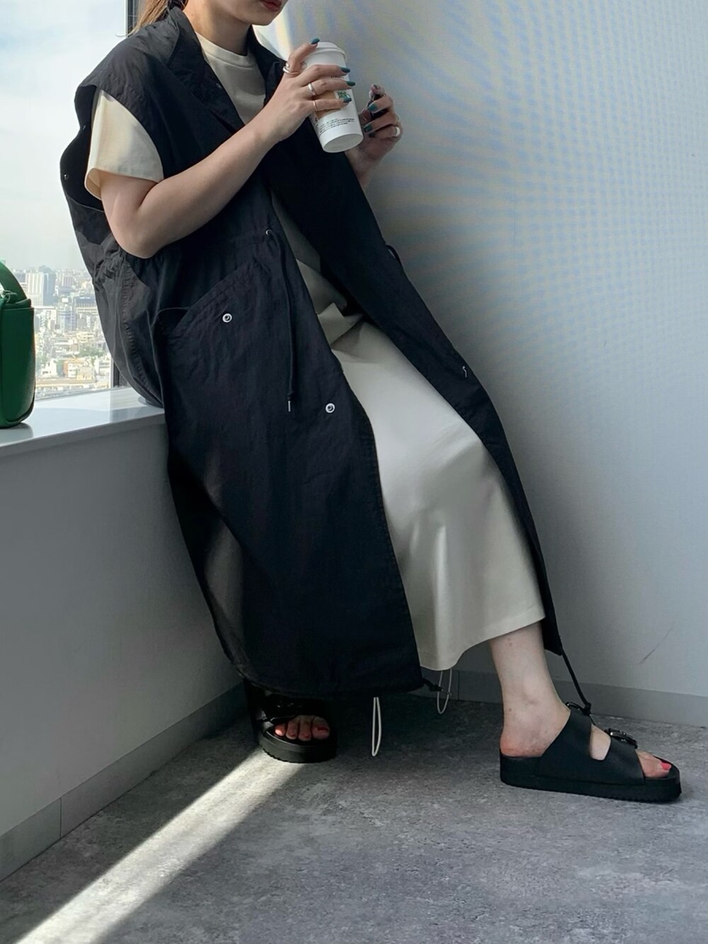 ブラック系のサンダル、ブラック系のジャケット/アウター、ブラック系のバッグを着用したレディースの夏コーディネートの3枚目の写真