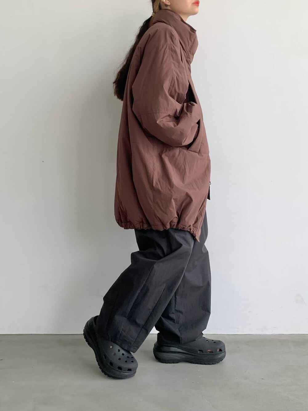 ブラック系のスラックス、ブラウン系のブルゾンを着用したレディースの夏コーディネートの4枚目の写真