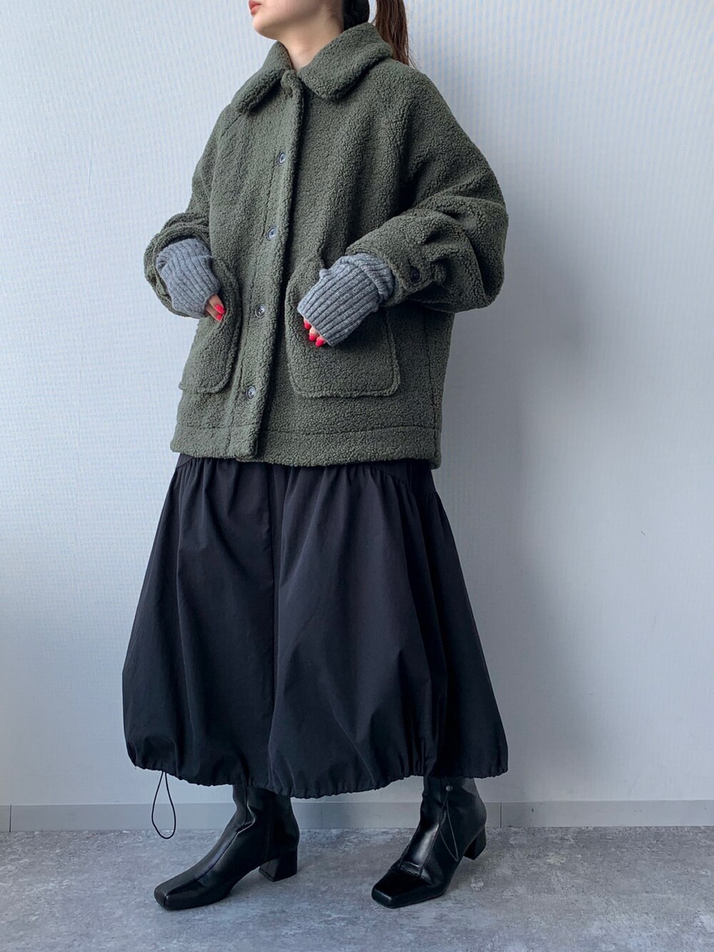 ブラック系のブーツ、グリーン系のブルゾン、ブラック系のワンピースを着用したレディースの夏コーディネートの3枚目の写真