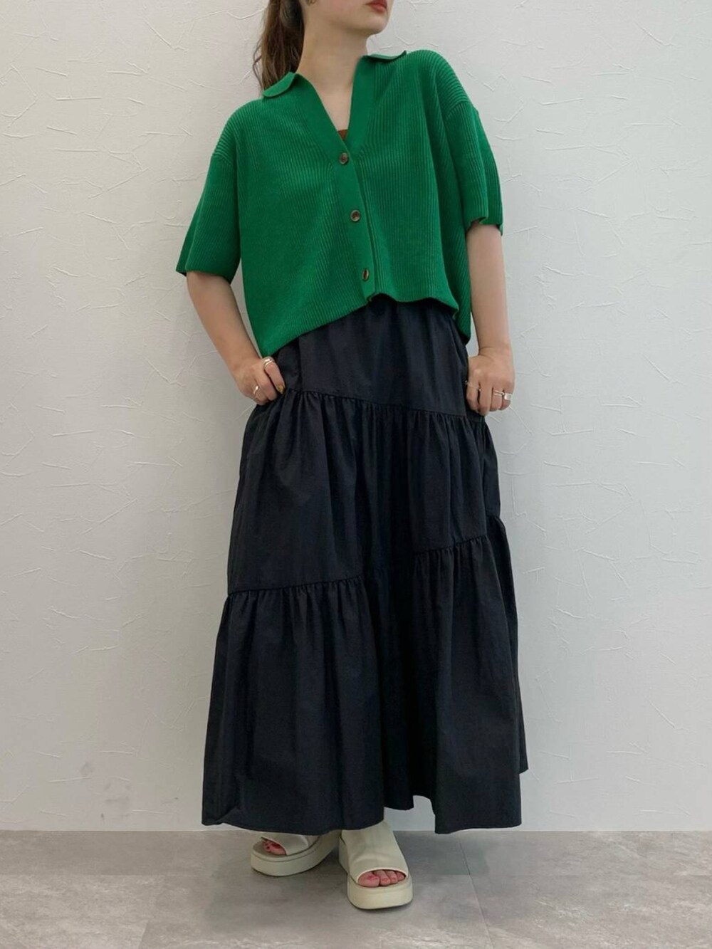 ブラック系のスカート、ホワイト系のサンダル、ブラック系のキャミソールを着用したレディースの夏コーディネートの3枚目の写真