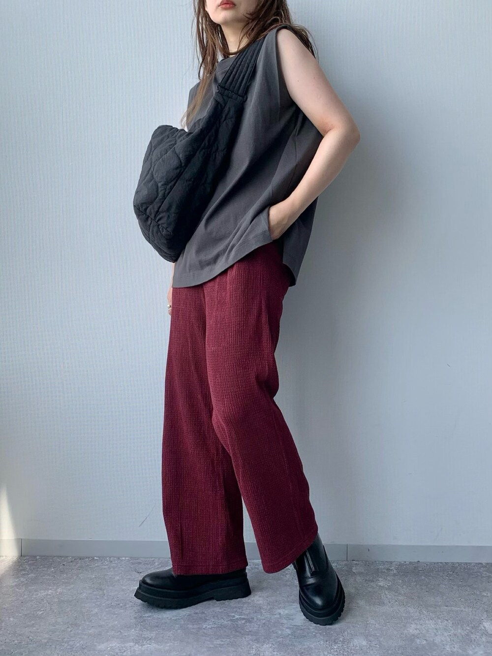 ブラック系のブーツ、レッド系のその他パンツ、グレー系のトップスを着用したレディースの夏コーディネートの2枚目の写真