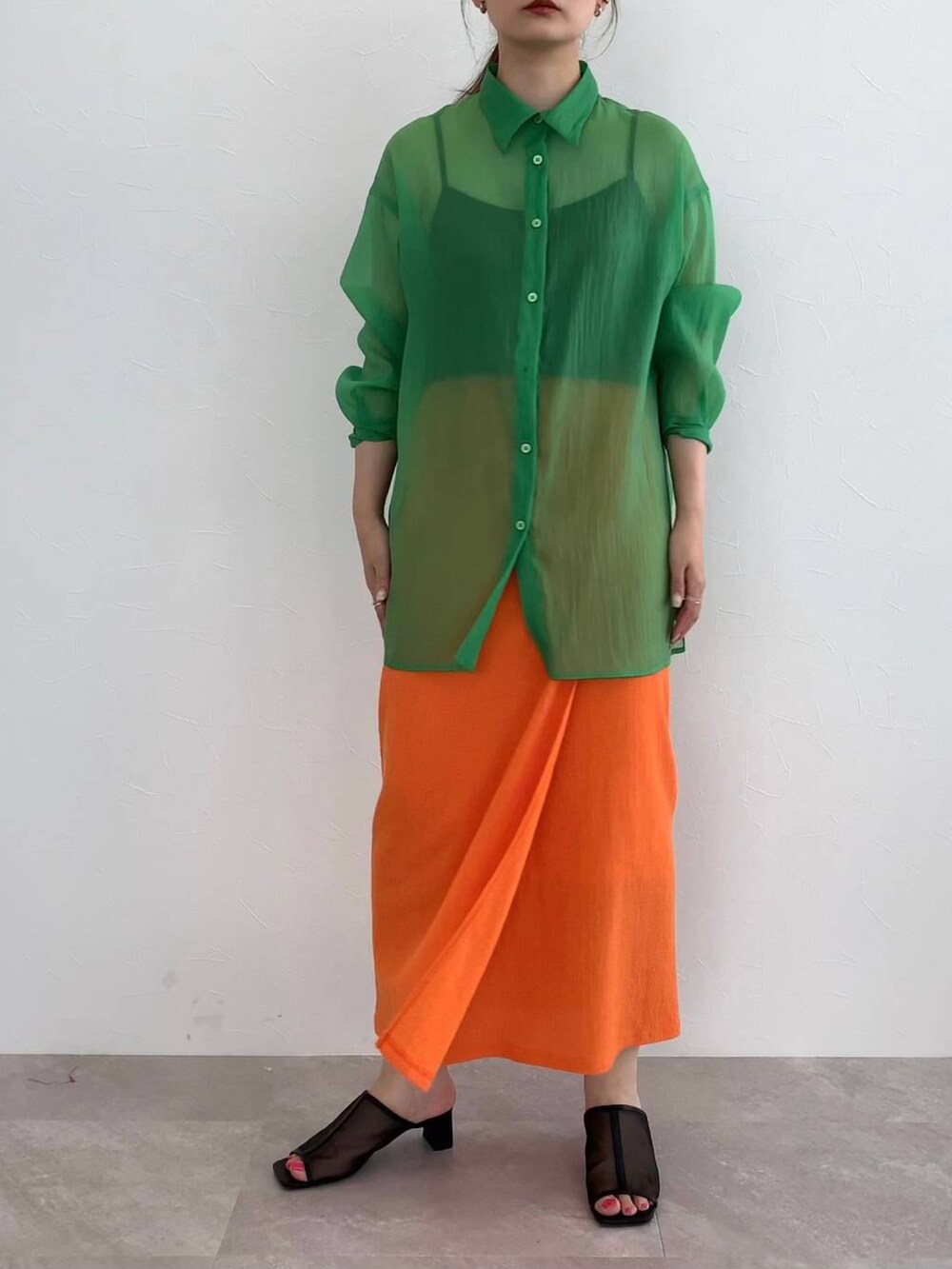 ブラック系のサンダル、オレンジ系のスカート、グリーン系のシャツ/ブラウスを着用したレディースの夏コーディネートの2枚目の写真