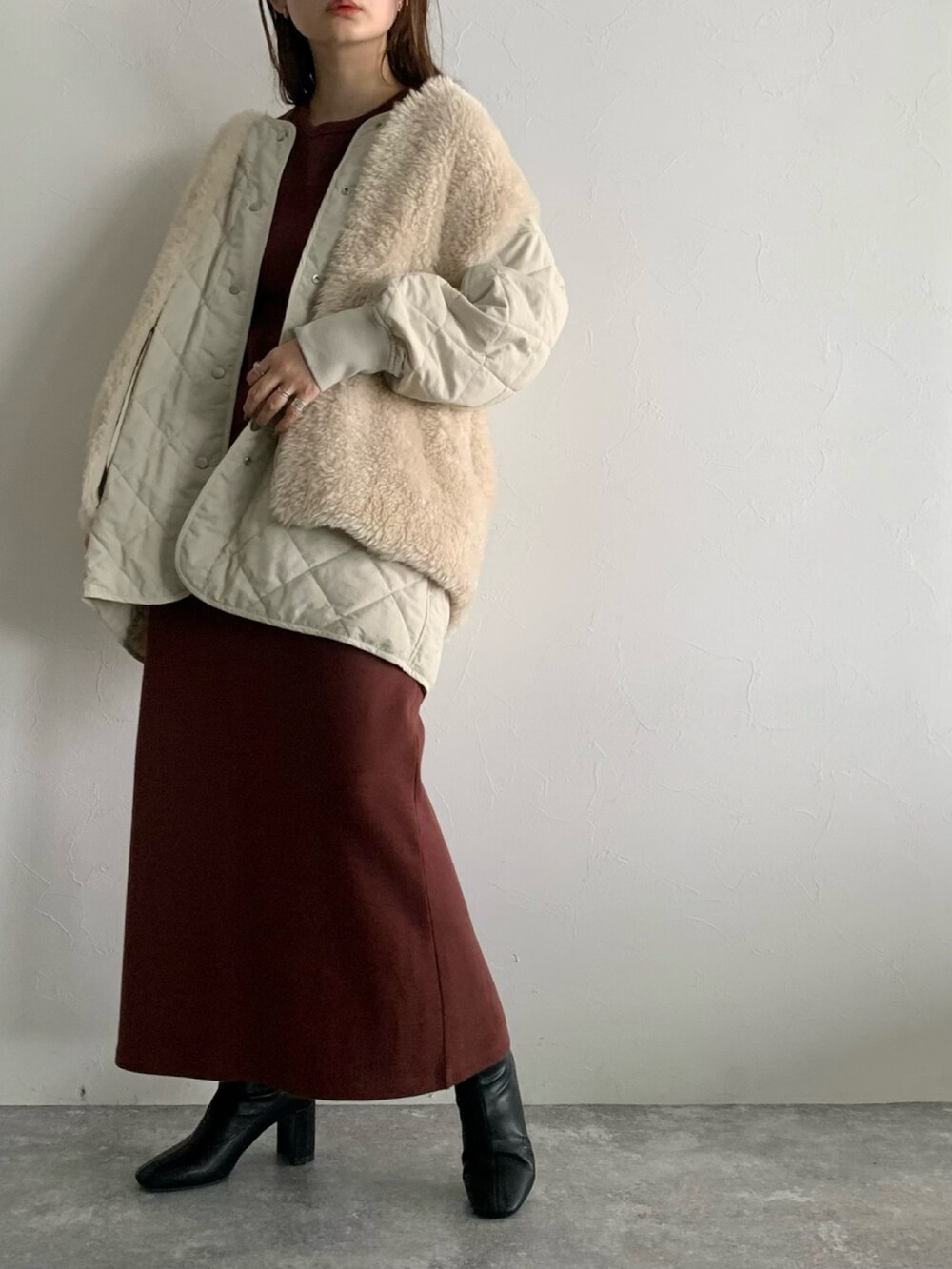 ブラウン系のワンピース、ブラック系のブーツ、ホワイト系のブルゾンを着用したレディースの夏コーディネートの2枚目の写真