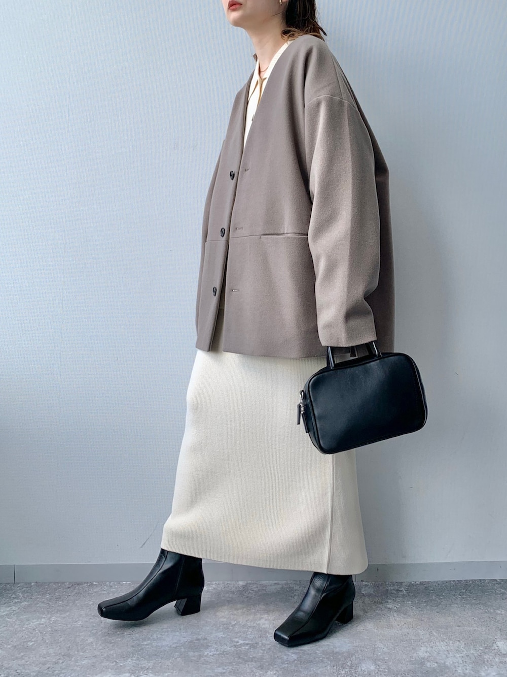 ブラック系のブーツ、ブラック系のショルダーバッグ、ホワイト系のワンピースを着用したレディースの夏コーディネートの2枚目の写真