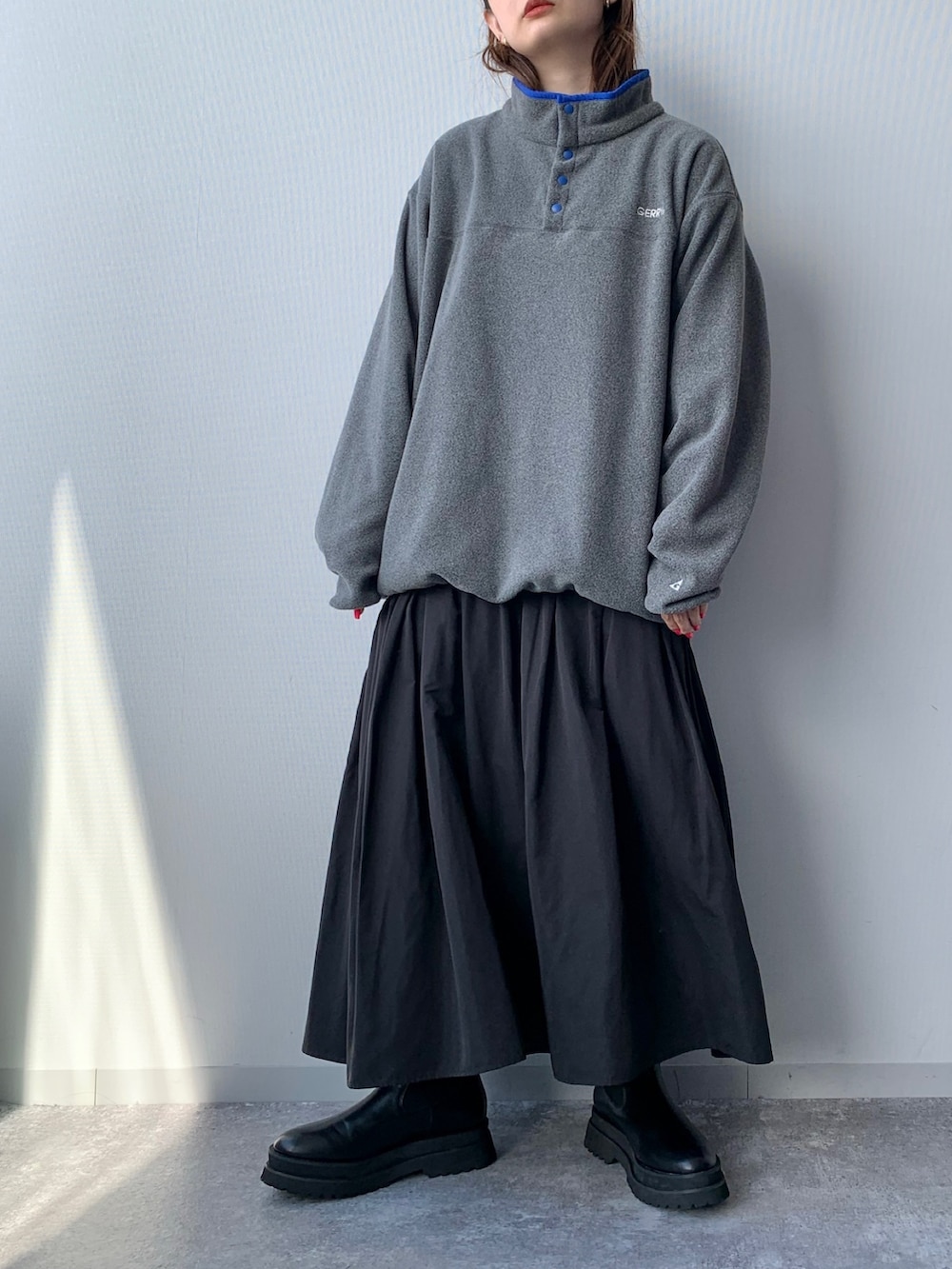 グレー系のTシャツ/カットソー、グリーン系のスカート、ブラック系のブーツを着用したレディースの夏コーディネートの2枚目の写真