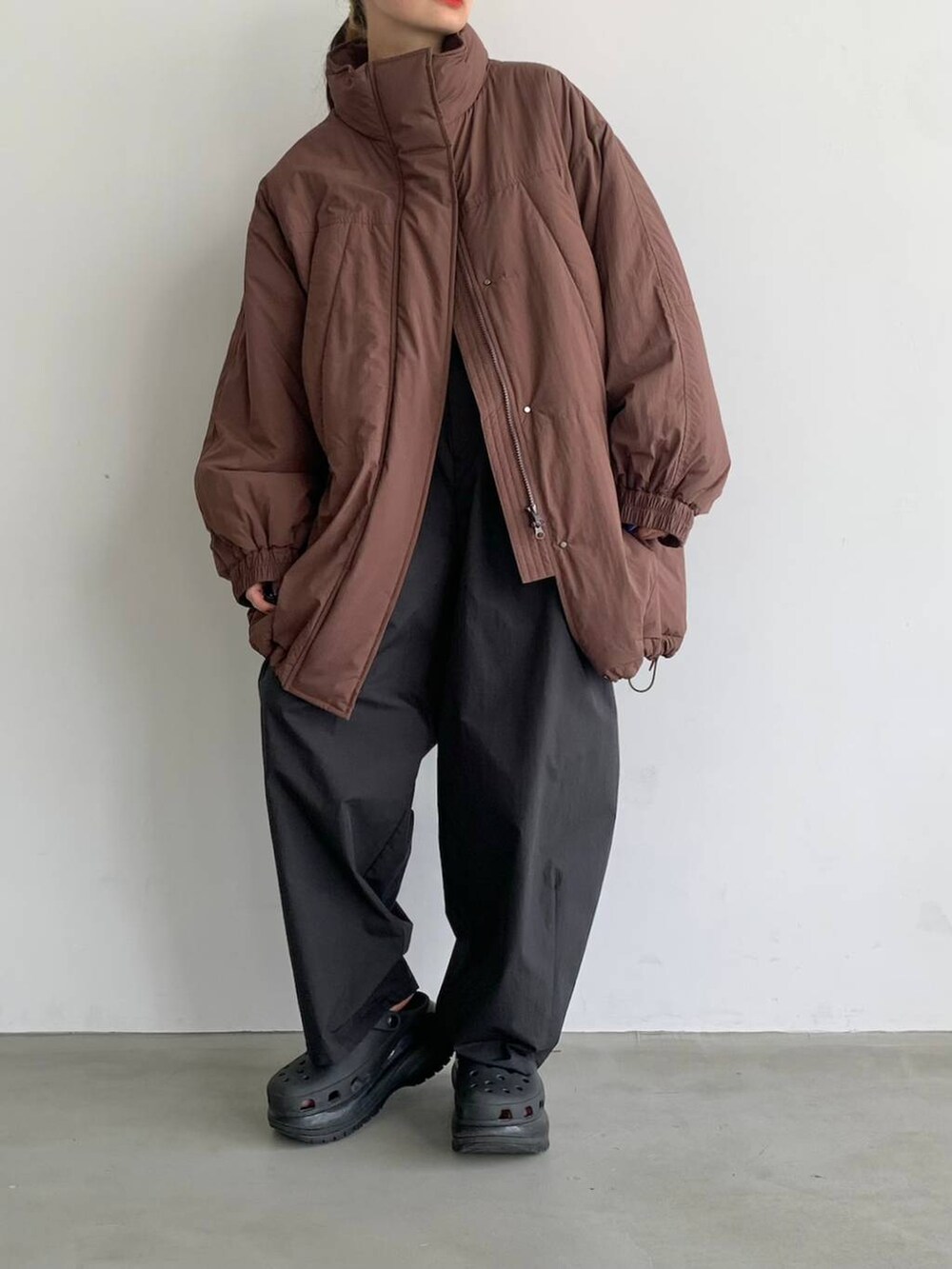 ブラック系のスラックス、ブラウン系のブルゾンを着用したレディースの夏コーディネートの3枚目の写真