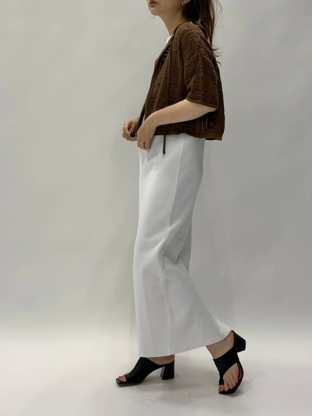 ブラウン系のワンピース、ブラウン系のカーディガン/ボレロ、ブラック系のサンダルを着用したレディースの夏コーディネートの2枚目の写真