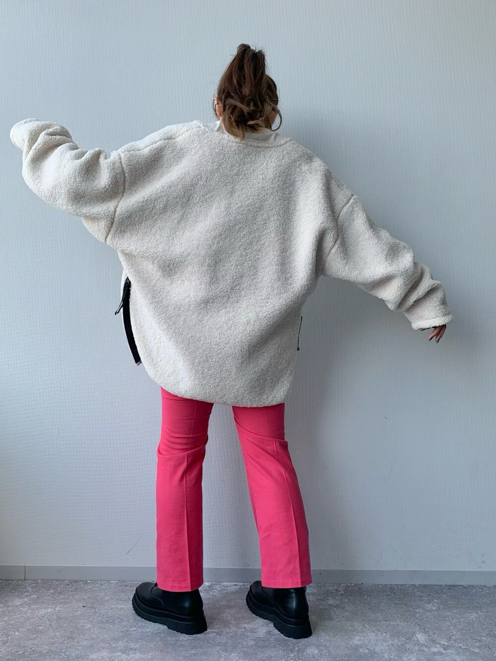 ホワイト系のブルゾン、ピンク系のスラックス、ブラック系のブーツを着用したレディースの夏コーディネートの4枚目の写真