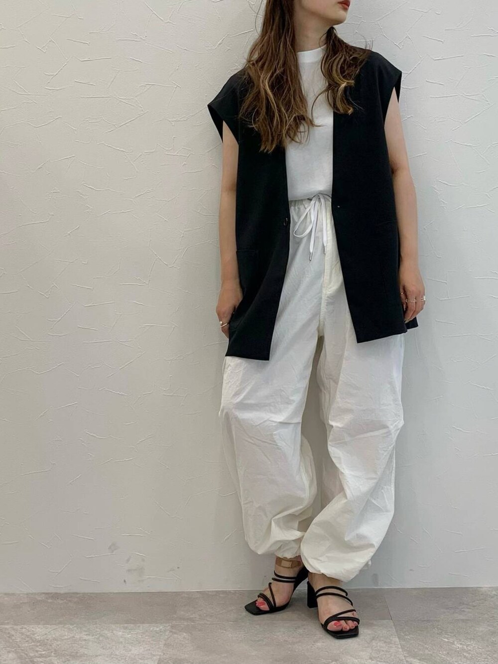 ブラック系のその他アウター、ホワイト系のその他パンツ、ブラック系のサンダルを着用したレディースの夏コーディネートの2枚目の写真