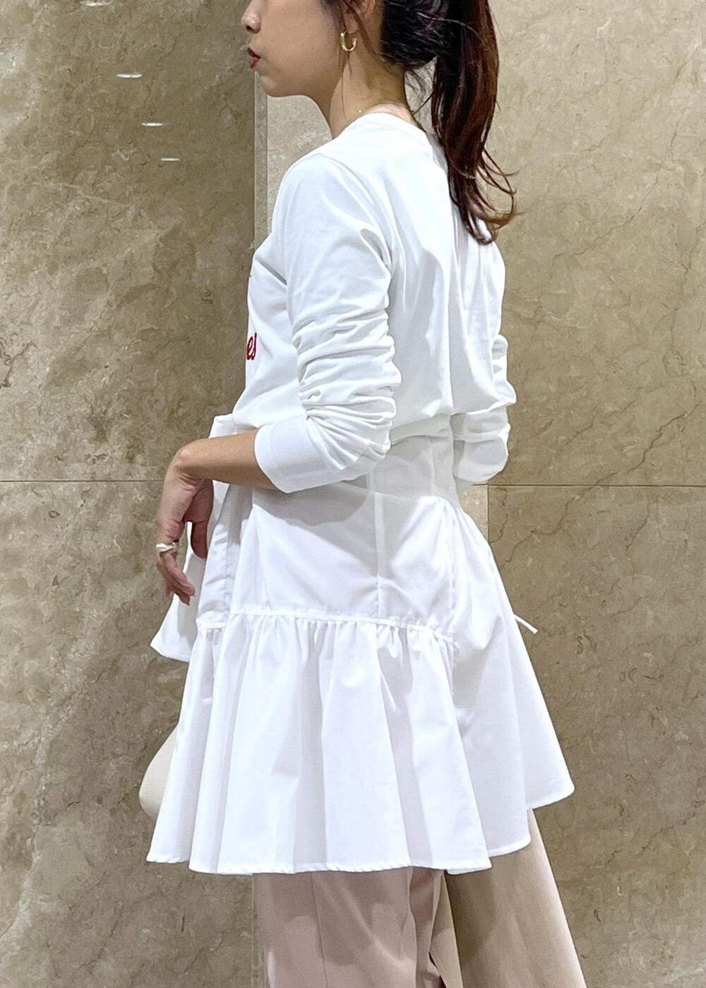 ホワイト系のハンドバッグ、シルバー系のパンプス、ホワイト系のシャツ/ブラウスを着用したレディースの冬コーディネートの9枚目の写真