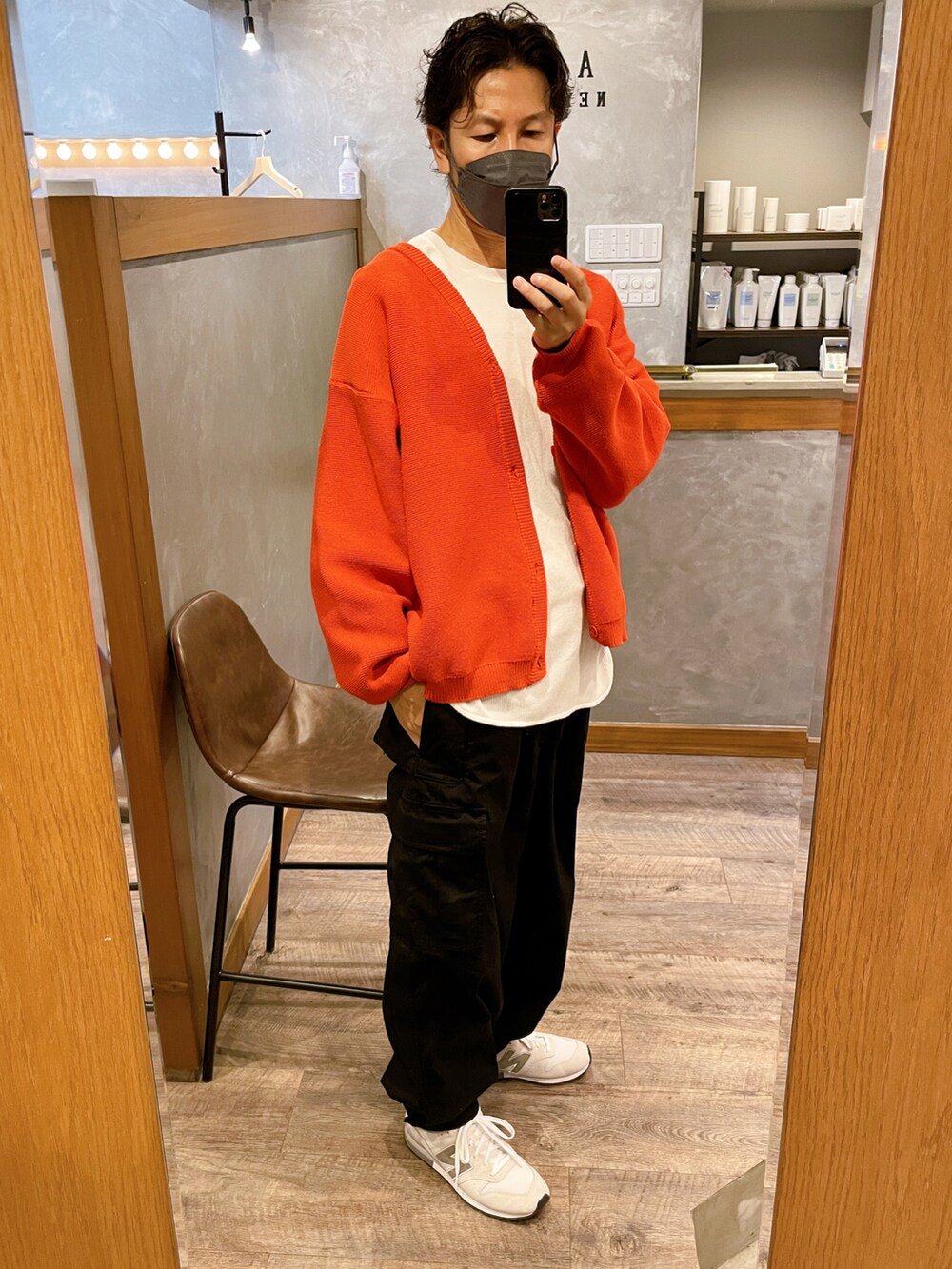 ブラック系のカーゴパンツ、ホワイト系のスニーカー、オレンジ系のカーディガン/ボレロを着用したメンズの秋コーディネートの2枚目の写真