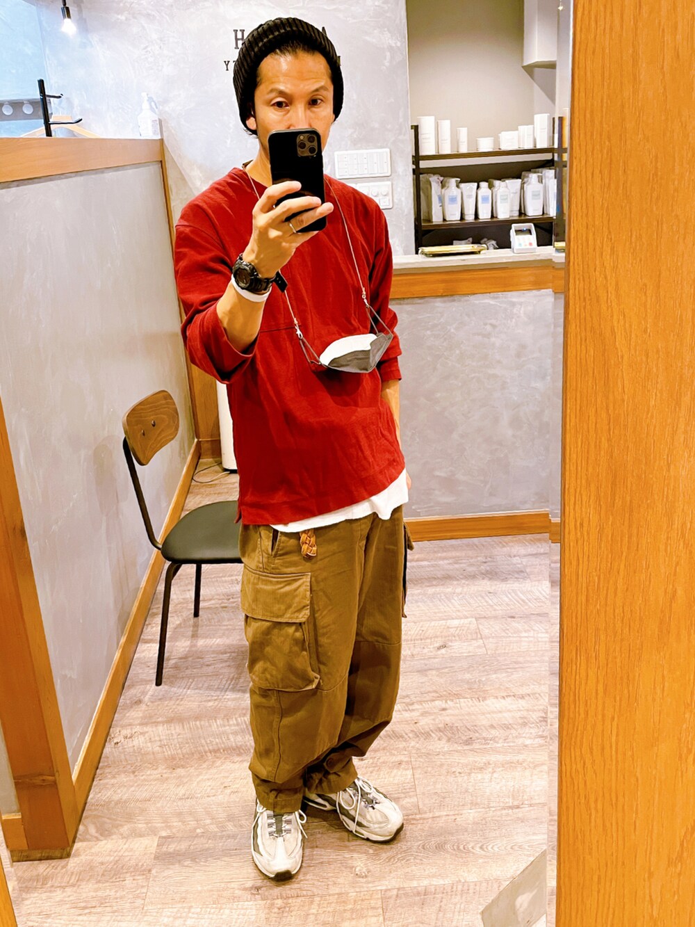 グレー系のスニーカー、ブラウン系のカーゴパンツ、レッド系のTシャツ/カットソーを着用したメンズの秋コーディネートの2枚目の写真