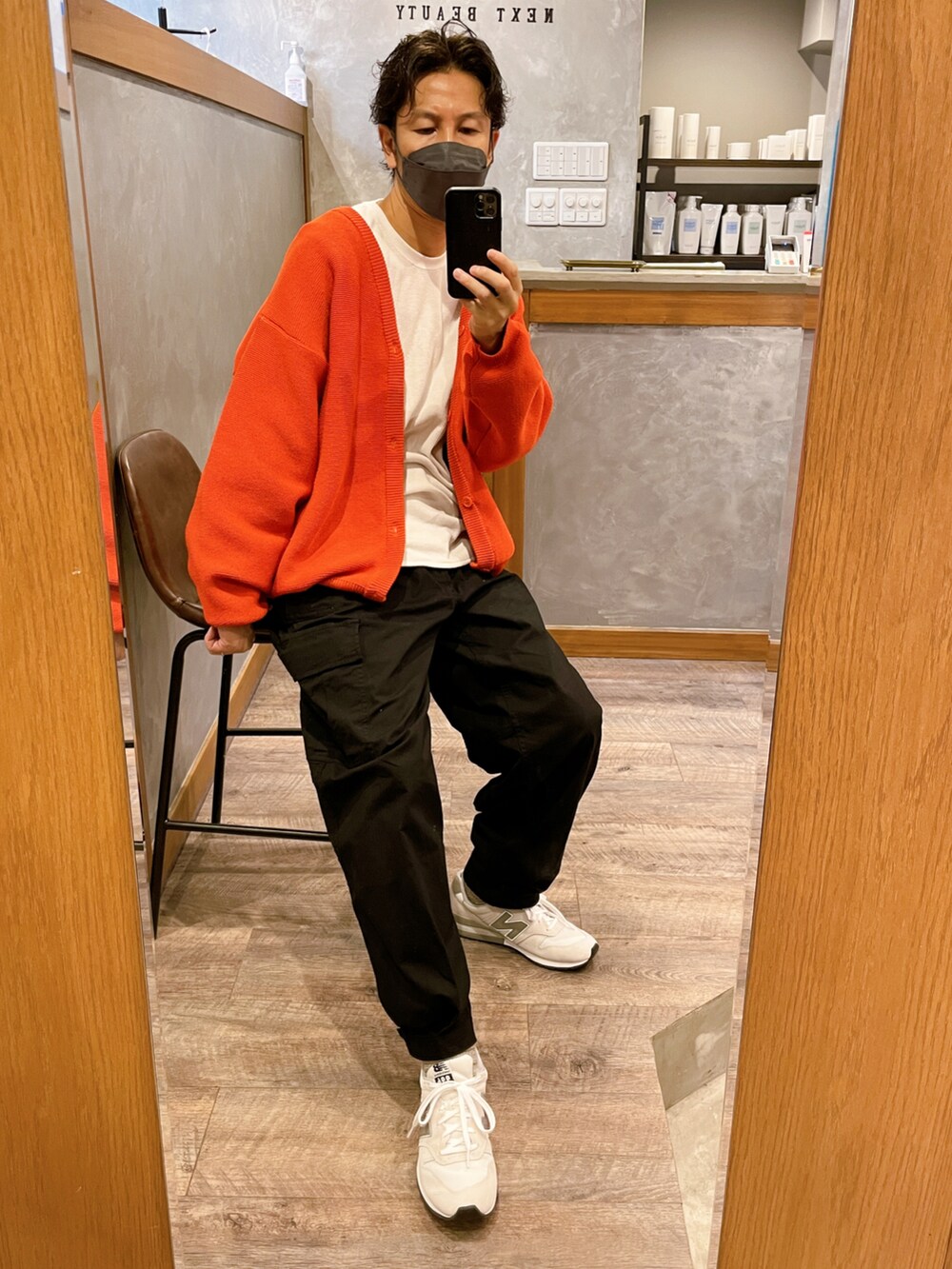 ブラック系のカーゴパンツ、ホワイト系のスニーカー、オレンジ系のカーディガン/ボレロを着用したメンズの秋コーディネートの3枚目の写真