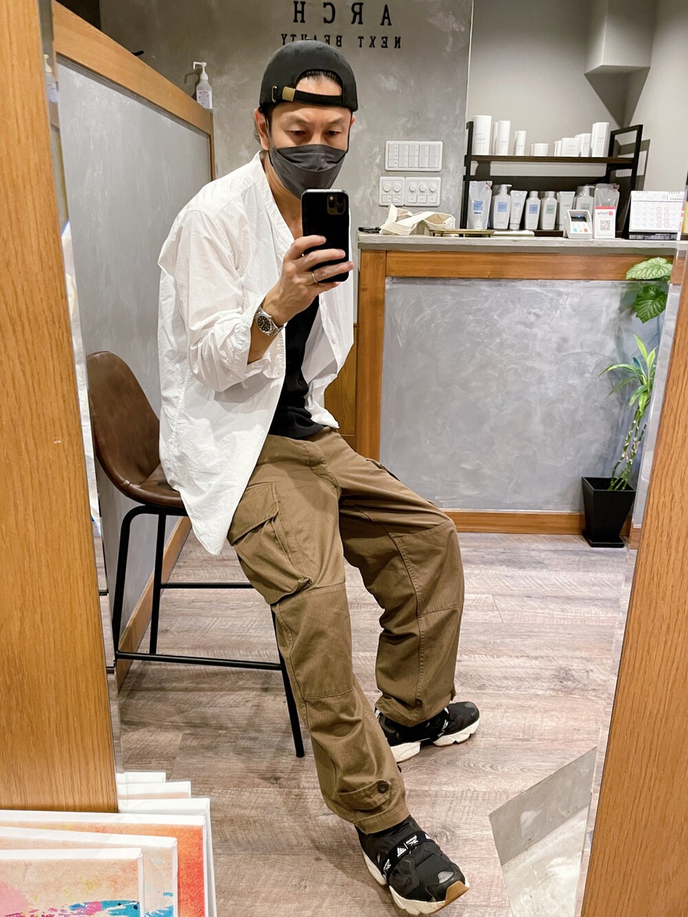 ブラック系のスニーカー、ブラウン系のカーゴパンツ、ホワイト系のシャツ/ブラウスを着用したメンズの秋コーディネートの2枚目の写真