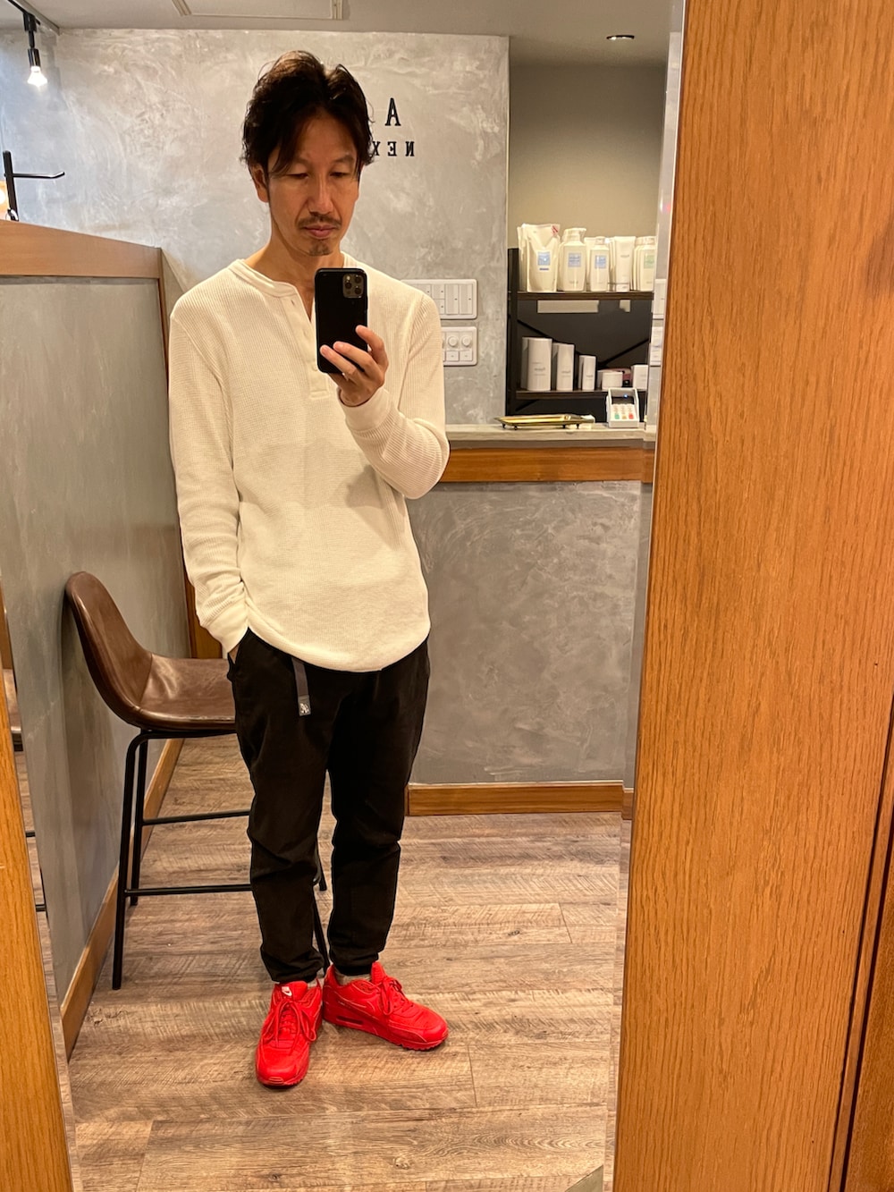 ブラック系のスウェットパンツ、レッド系のスニーカー、ホワイト系のTシャツ/カットソーを着用したメンズの秋コーディネートの2枚目の写真