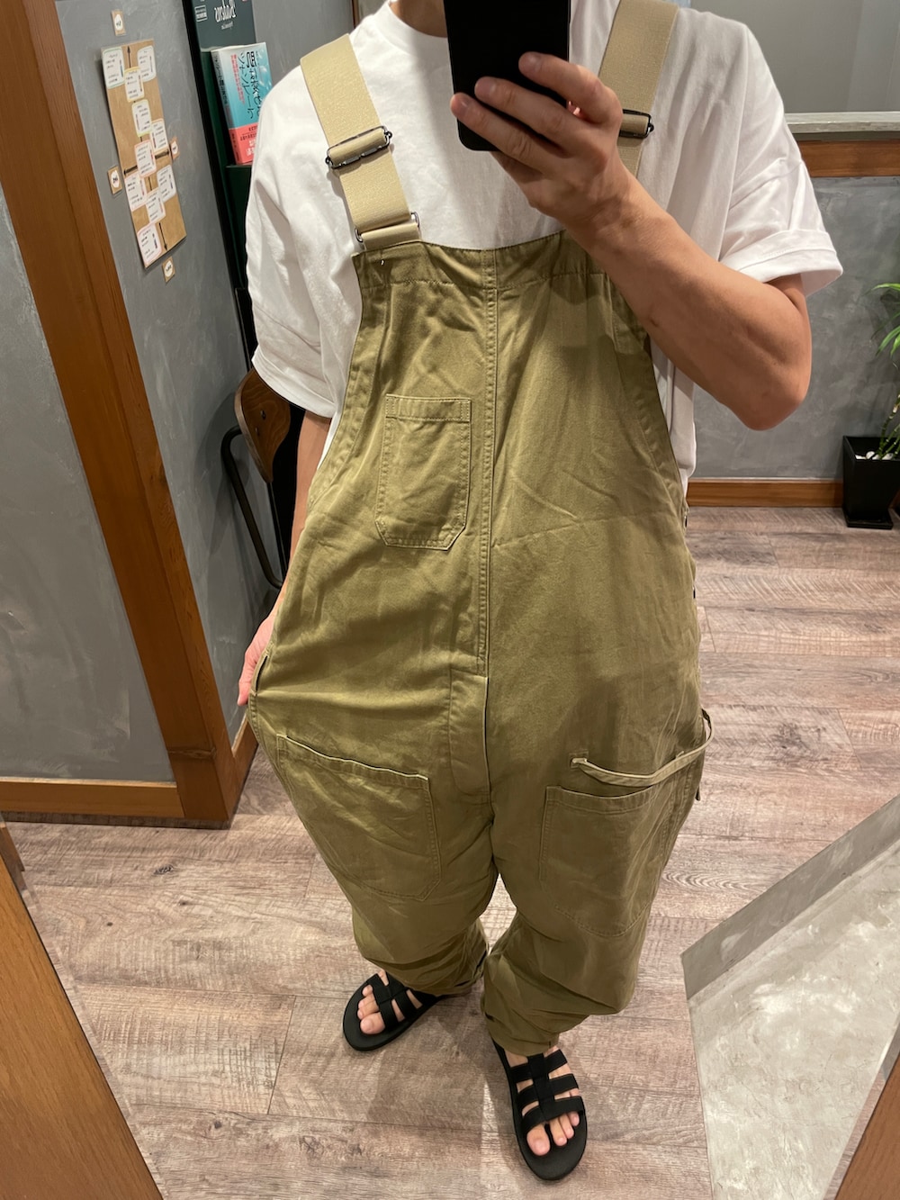 ベージュ系のサロペット/オーバーオール、ホワイト系のTシャツ/カットソー、ブラック系のサンダルを着用したメンズの夏コーディネートの2枚目の写真