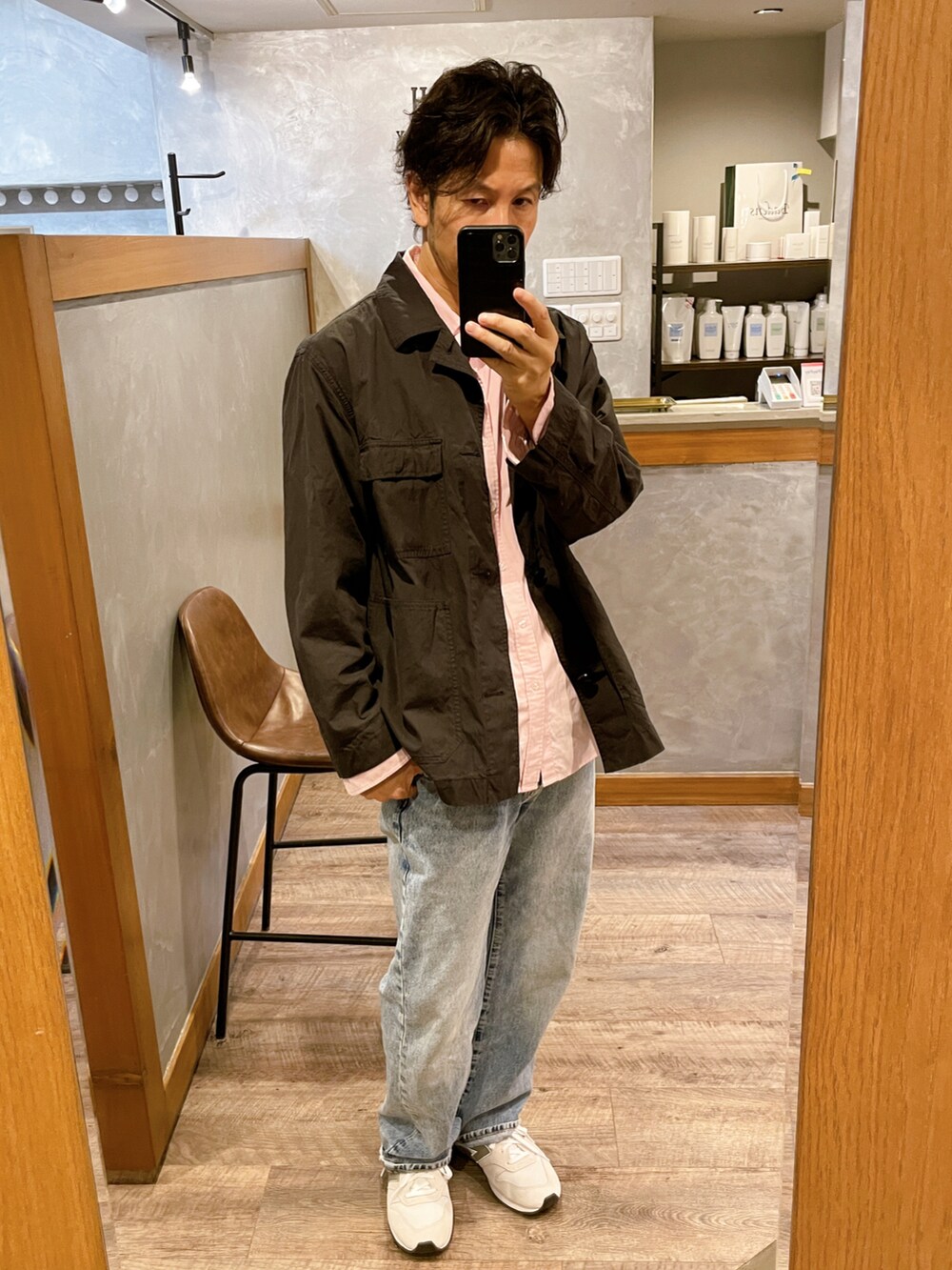 ブルー系のデニムパンツ、ホワイト系のスニーカー、ピンク系のシャツ/ブラウスを着用したメンズの秋コーディネートの2枚目の写真